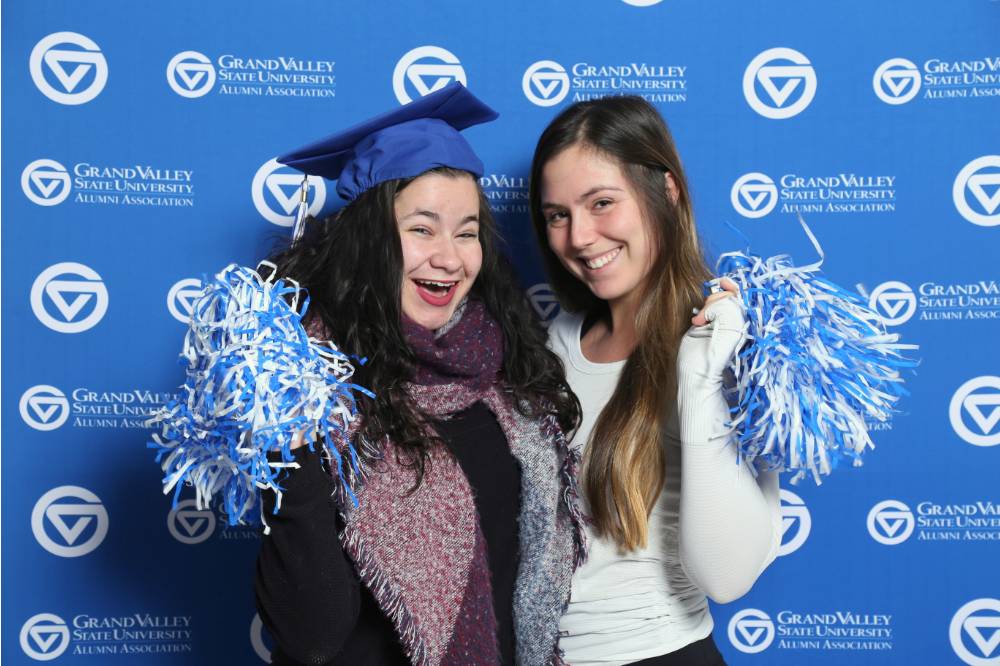 Two students pose with props at GradFest